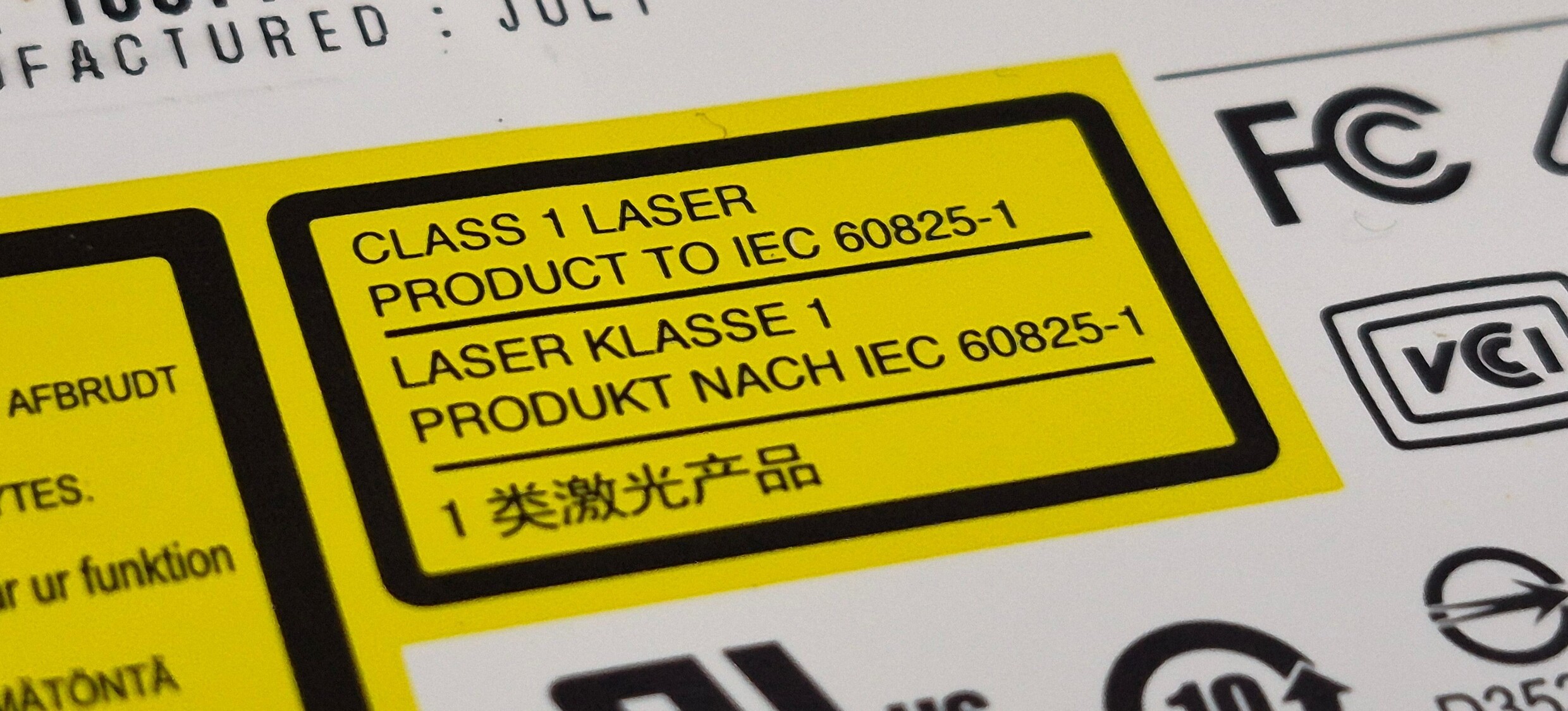 Close-up of a CD player with a yellow Class 1 Laser Product sticker